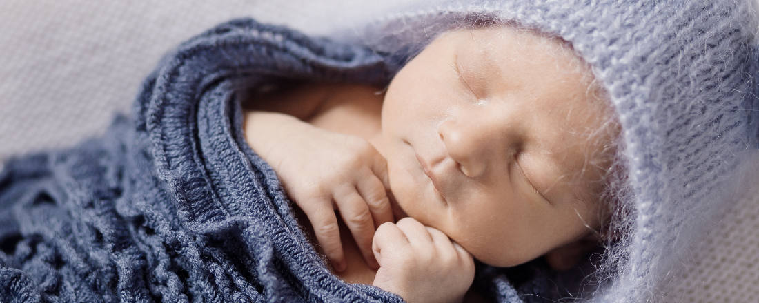 Image-du-Blog-ruedeloeuvre-represente-un-beau-bebe-qui-dort-dans-un-ensemble-bleu-pour-larticle-comment-preparer-une-seance-photo-de-naissance